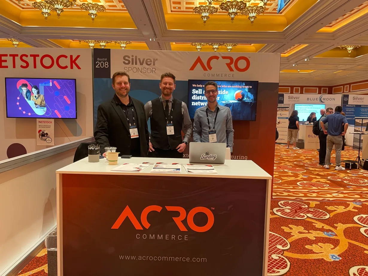 Acumatica Summit 2024 Recap | Kyle, Jared & Steve standing at the Acro Commerce booth, smiling and being friendly