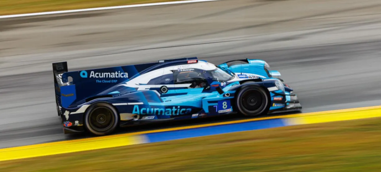 Acumatica | Image of a race car on a track with the Acumatica logo prominently displayed on the fin | Acro Commerce